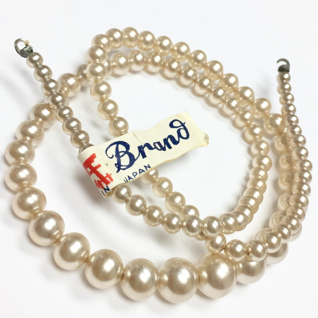 vintage pearl beads with a tag labeled 'brand japan'