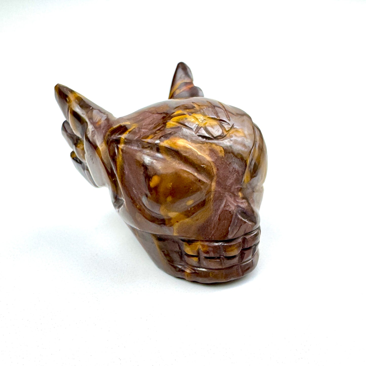 carved stone skull with wings and yellow-brown hues