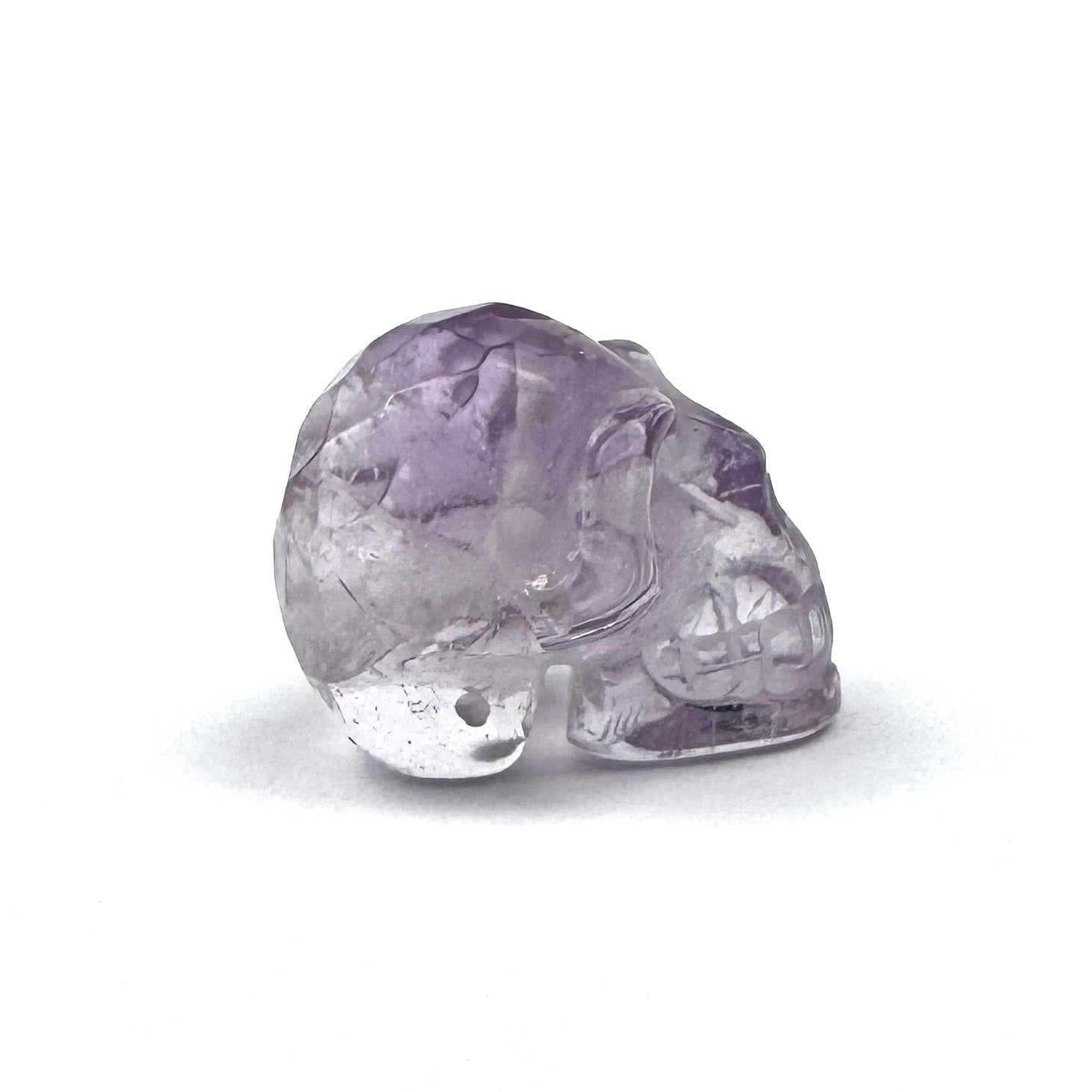 side view of a carved amethyst skull figurine